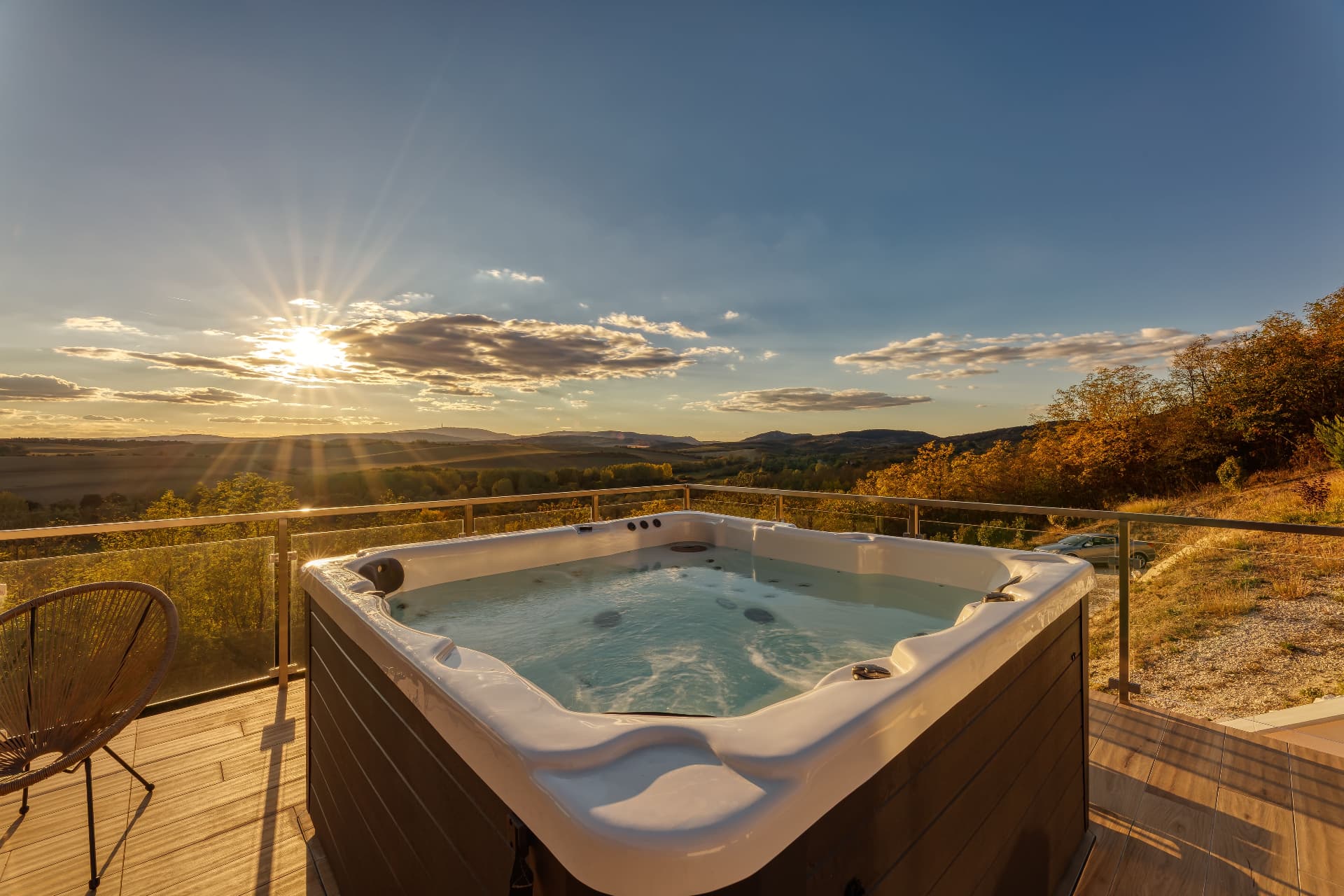 Kültéri jacuzzi a teraszon, naplementében, a dombokre nyíló panorámával